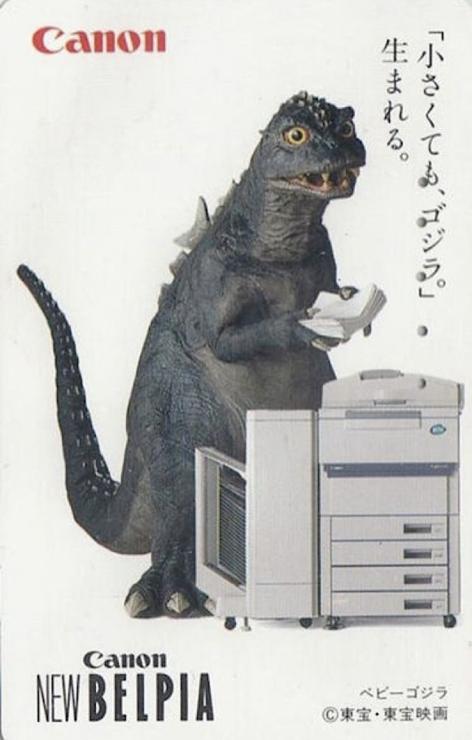 Smallish Godzilla at a photocopy machine, holding a stack of paper, looking off into the distance as if taking a mental break