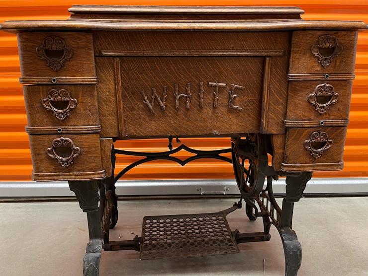 Vintage White sewing machine cabinet, folded closed with machine inside.